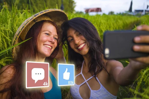 Aplicación le gusta y comentarios alimentación compuesta con jóvenes exitosas y felices chicas turísticas tomando novias selfie juntos en hermoso paisaje tropical — Foto de Stock