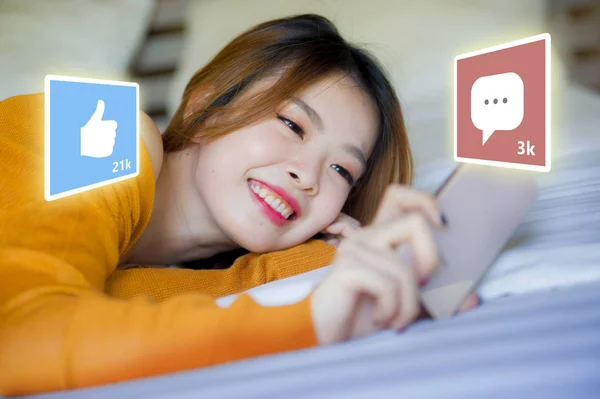 Estilo de vida retrato de la joven mujer coreana asiática feliz y atractiva utilizando Internet teléfono móvil compuesto con aplicaciones de redes sociales le gusta y chat comentarios iconos —  Fotos de Stock