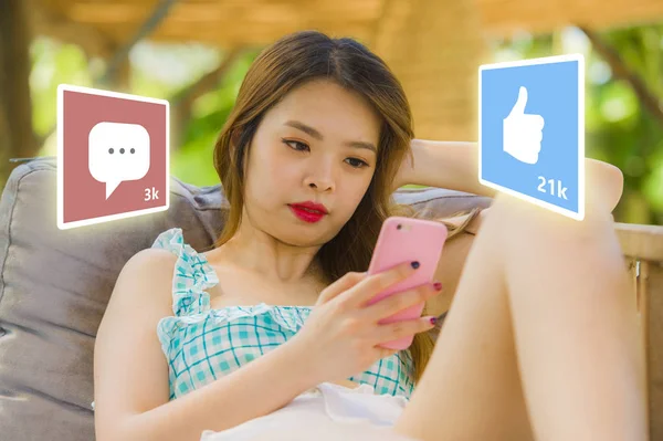 Estilo de vida retrato de la joven mujer china asiática feliz y atractiva usando Internet teléfono móvil compuesto con aplicaciones de redes sociales le gusta y chat comentarios iconos —  Fotos de Stock