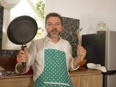  ev aşçı tutan tava ve tencere ev işleri memnun gülümseyen serin poz mutfak önlük giyen 30s-40s mutlu ve çekici adam yaşam tarzı portre