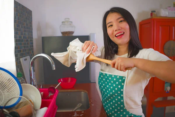 Retrato de estilo de vida natural de jovem bela e feliz mulher asiática coreana em avental e luva de borracha lavar e secar pratos alegres em tarefas domésticas relaxadas — Fotografia de Stock