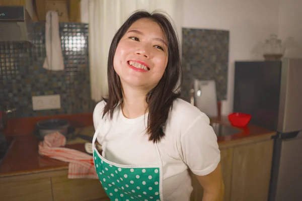 Retrato de estilo de vida natural de jovem bonita e feliz mulher asiática coreana em avental de cozinha segurando pano de prato sorrindo alegre desfrutando de tarefas domésticas e limpeza — Fotografia de Stock