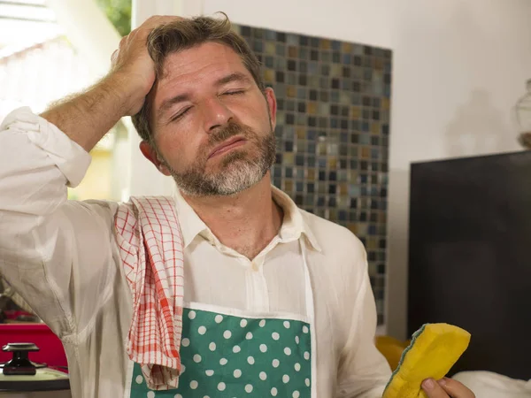 Potret gaya hidup lucu dari orang dewasa pertengahan yang tidak bahagia dan menekankan pria di apron dapur merasa frustrasi dan kesal dengan pekerjaan rumah tangga mencuci piring lelah menderita stres — Stok Foto