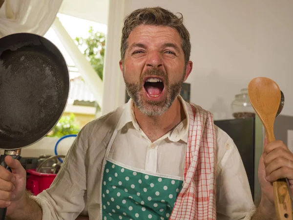 unhappy and stressed man in kitchen apron feeling frustrated and upset overwhelmed by domestic chores washing dishes tired screaming desperate in stress