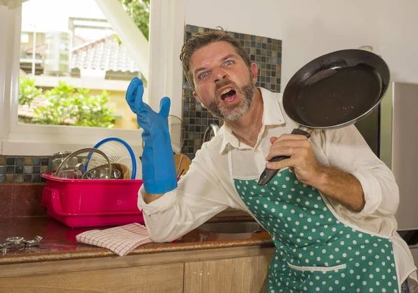 Unglücklicher und gestresster Mann in Küchenschürze, der sich frustriert und aufgebracht fühlt, überwältigt von häuslicher Arbeit, die Geschirr spült, müde schreiend, verzweifelt im Stress — Stockfoto