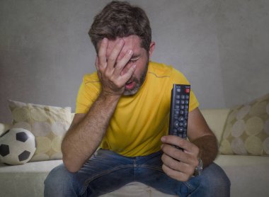 üzgün ve sinirli adam Tv'de Avrupa futbol maçı izlerken oturma odası kanepede tek başına üzgün ve mutsuz ekibi kaybetme ile duygu oturan