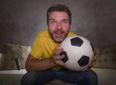 çekici ve stresli adam tv tezahürat futbol oyunu izlerken evde oturma odası kanepede oturan heyecanlı ve yoğun duygu stres maç zevk mutlu