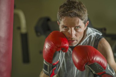 serin ve badass savaşçı bakmak ağır çanta delme fitness kulübünde boks eldiven eğitimi çekici ve şiddetli görünümlü boksör adam 30s 40s spor egzersiz portre