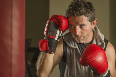 serin ve badass savaşçı bakmak ağır çanta delme fitness kulübünde boks eldiven eğitimi çekici ve şiddetli görünümlü boksör adam 30s 40s spor egzersiz portre