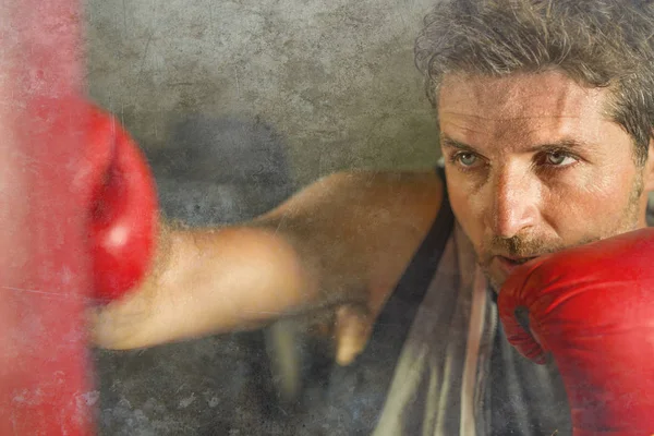 serin ve badass savaşçı bakmak ağır çanta delme fitness kulübünde boks eldiven eğitimi çekici ve şiddetli görünümlü boksör adam 30s 40s spor egzersiz portre
