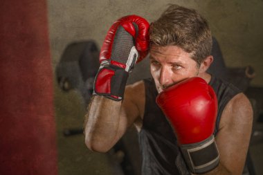 serin ve badass savaşçı bakmak ağır çanta delme fitness kulübünde boks eldiven eğitimi çekici ve şiddetli görünümlü boksör adam 30s 40s spor egzersiz portre
