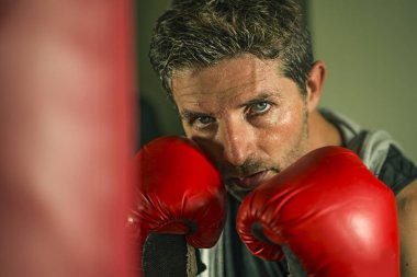 serin ve badass savaşçı bakmak ağır çanta delme fitness kulübünde boks eldiven eğitimi çekici ve şiddetli görünümlü boksör adam 30s 40s spor egzersiz portre