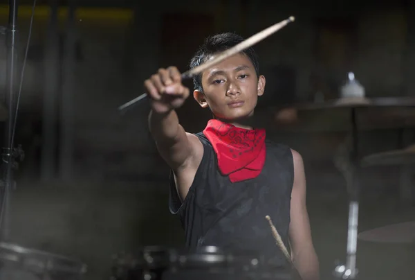 Mladý chlapec jako bubeník rockové kapely. portrét na jevišti hezkého a chladného asijského teenagera hrající na bicí souprava představení noční hudba show — Stock fotografie