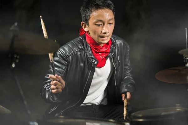 Jovem músico adolescente legal e talentoso tocando bateria em seu 14 anos de idade em jaqueta de couro e estilo banda de bandana rock praticando e executando música no palco — Fotografia de Stock