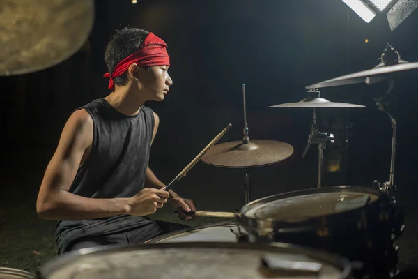 Asiático americano adolescente misto tocando bateria em casa jardim. legal e bonito jovem garoto praticando no kit de bateria ensaiando apaixonado no olhar banda de rock badass — Fotografia de Stock