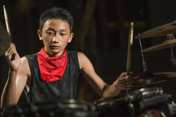 Asiatisk amerikansk blandad tonåring spelar trummor hemma trädgård. cool och stilig ung pojke öva på trumset repeterande passionerad i badass rock band look — Stockfoto
