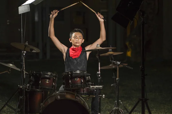 Asiático americano adolescente misto tocando bateria em casa jardim. legal e bonito jovem garoto praticando no kit de bateria ensaiando apaixonado no olhar banda de rock badass — Fotografia de Stock