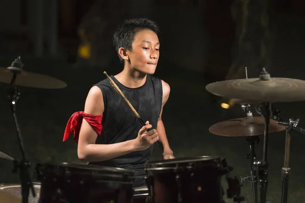 Asiático americano adolescente misto tocando bateria em casa jardim. legal e bonito jovem garoto praticando no kit de bateria ensaiando apaixonado no olhar banda de rock badass — Fotografia de Stock