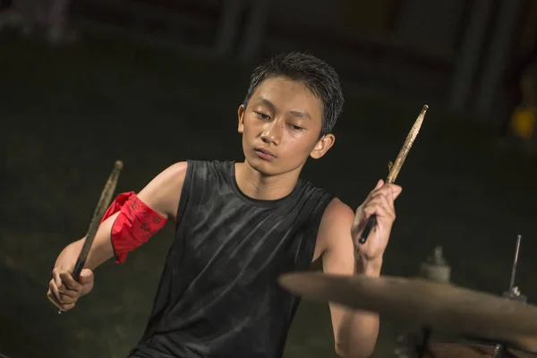 Asiático americano adolescente misto tocando bateria em casa jardim. legal e bonito jovem garoto praticando no kit de bateria ensaiando apaixonado no olhar banda de rock badass — Fotografia de Stock