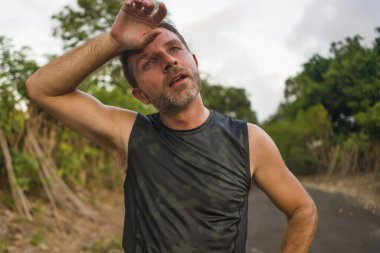 Spor ve spor yaşam tarzı. Genç, çekici, terli ve yorgun bir adamın portresi. Açık havada koşmaktan yorgun düşmüş.