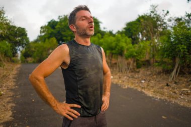 Spor ve spor yaşam tarzı. Genç, çekici, terli ve yorgun bir adamın portresi. Açık havada koşmaktan yorgun düşmüş.
