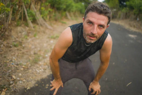 Esporte e fitness estilo de vida retrato de jovem atraente suado e cansado homem exausto depois de correr ao ar livre treino em respiração bela estrada país — Fotografia de Stock