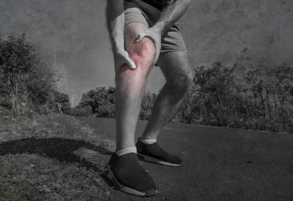 Spor yapan bir adamın spor kazasında ve sağlık konseptinde spor yaparken dizine dokunarak acı çekmesi ya da sakatlanması sonucu ellerini ve bacaklarını kapatın.