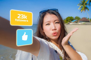 young beautiful and happy influencer Korean woman taking self portrait getting likes and new followers in travel blogger success
