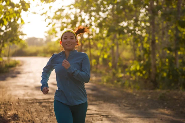 Jovem feliz mulher asiática correndo em madeira no pôr do sol. Atraente a — Fotografia de Stock