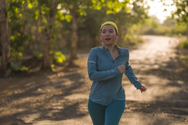 Jovem feliz mulher asiática correndo em madeira no pôr do sol. Atraente a — Fotografia de Stock