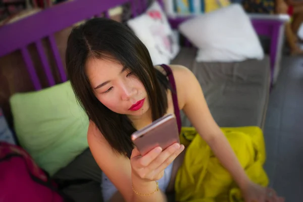 Estilo de vida retrato de la joven hermosa y relajada estudiante coreana asiática utilizando redes sociales en línea aplicación de redes sociales con teléfono de la mano al aire libre en el café fresco —  Fotos de Stock