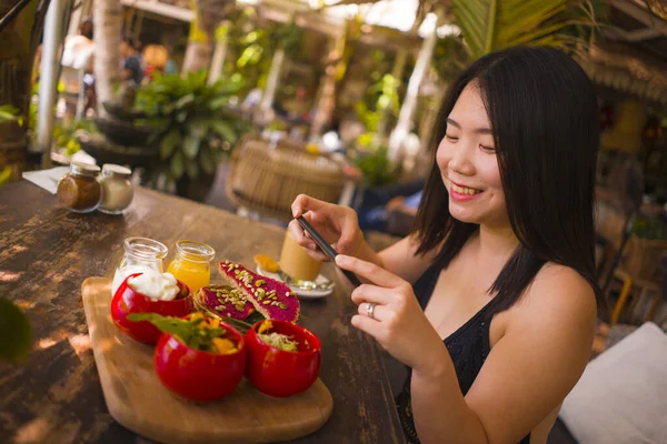 Jovem bela mulher asiática tira foto de comida com telefone para blog internet. Menina chinesa postando foto online para mídia social orgânica vegetariana — Fotografia de Stock