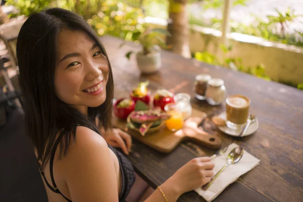 Un almuerzo vegetariano. estilo de vida natural retrato de joven feliz y hermosa mujer china asiática comiendo al aire libre teniendo desayuno orgánico en café fresco en la comida vegetariana — Foto de Stock