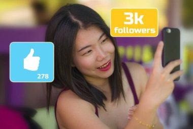 Genç tatlı ve mutlu Asyalı Koreli kız dışarıda cep telefonuyla selfie çekiyor. Sosyal medya uygulamaları ve online takipçi ikonu ile bestelenmiş.
