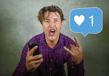 Sosyal medya bağımlılığı ve saplantı. Mutlu ve heyecanlı genç adamın komik portresi. İnternette tek bir kişiyi kutluyor. Cep telefonuna bakan internet uygulaması gibi.