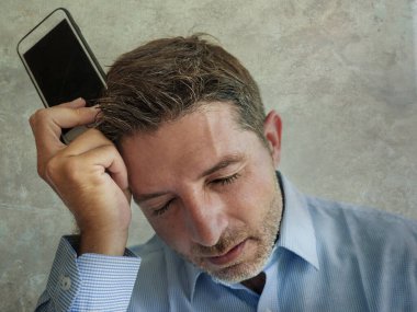Hüsrana uğramış ve bunalımda olan iş adamı stresli bir şekilde cep telefonu tutuyor. Hayal kırıklığına uğramış hissediyor. Baş ağrısı ve endişe hissediyor.