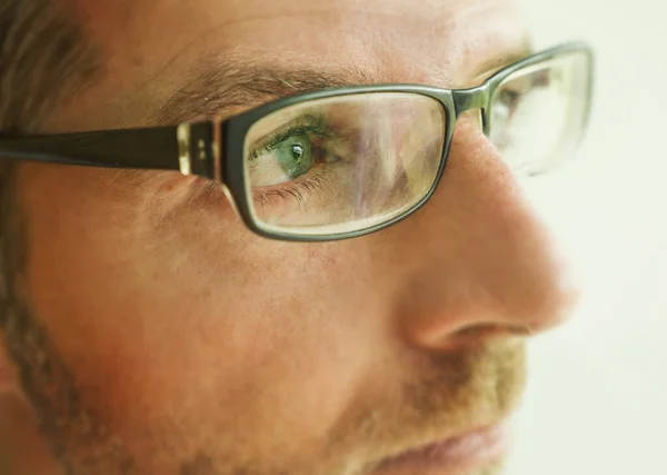 Primer plano retrato de la cara del hombre de los años 40 en gafas de aspecto reflexivo y serio en el estudio sobre un fondo claro — Foto de Stock