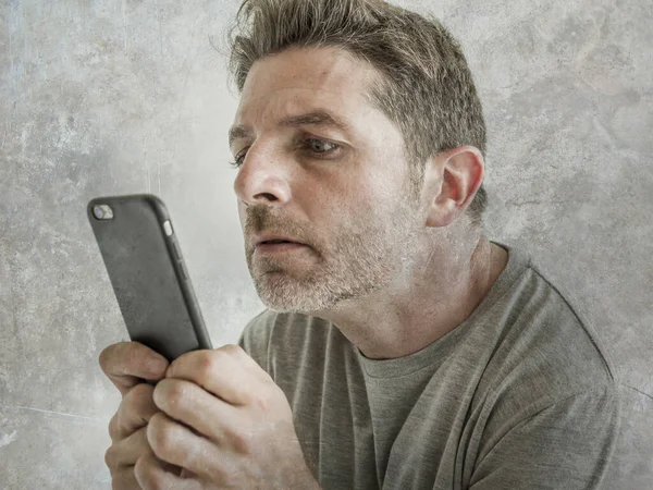 Bizarre et bizarre homme à la recherche en utilisant le téléphone mobile regarder quelque chose en ligne dans l'expression de visage intense malade dans Internet et concept de dépendance aux médias sociaux isolé — Photo