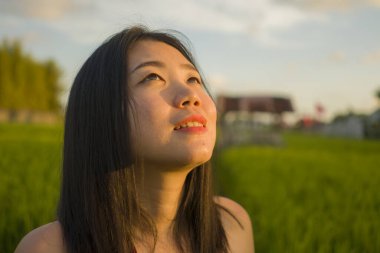 Genç ve güzel Asyalı kadın pirinç tarlasında doğanın tadını çıkarıyor. Gezgin şehvet ve turizm konseptiyle seyahat ederken kırsal bölgeleri keşfeden tatlı Çinli kız.