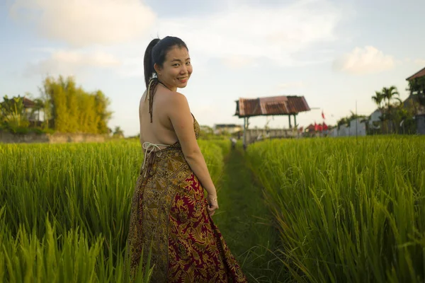 Jovem feliz e bela mulher asiática desfrutando da natureza no campo de arroz. menina coreana doce explorando o campo durante viagens de férias em conceito de vadiagem e turismo — Fotografia de Stock