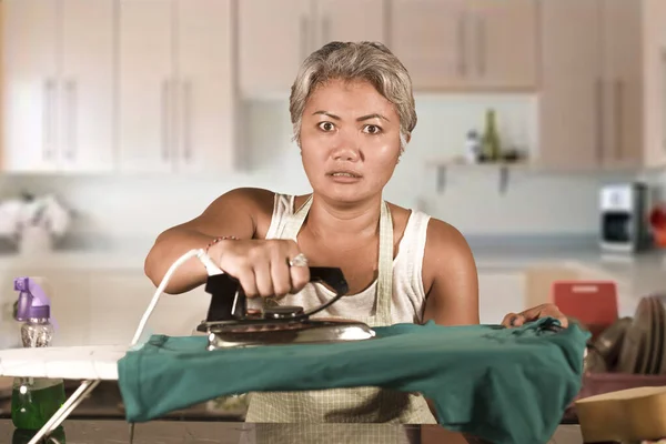 Attrayant bouleversé et stressé femme 40s à 50 repassage fatigué et malheureux à la maison cuisine faire des travaux ménagers et ennuyeux ménage frustré comme occupé ménage femme — Photo