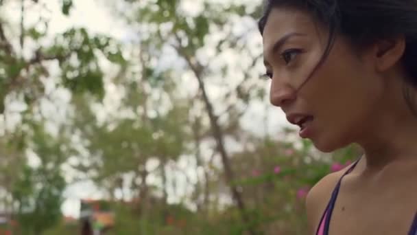 年轻迷人 口渴的亚洲女人在美丽的绿色公园里做了艰苦的跑步锻炼后 身体降 生活健康地冷却了下来 慢动作剑法射中了她 — 图库视频影像