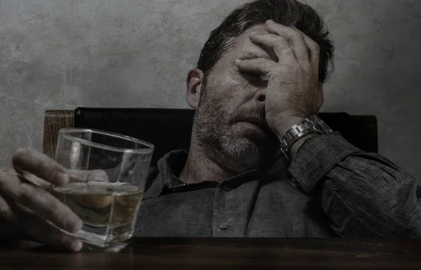 Alcoholische depressieve en verspilde verslaafde man die voor whiskyglas zit en probeert te drinken in dramatische bewoordingen die lijden aan alcoholisme en alcoholverslaving — Stockfoto