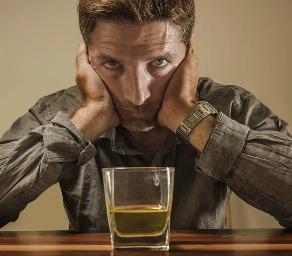 Depressiver und nachdenklicher Alkoholiker um die 40 vor verschwendetem Whiskeyglas und gestresstem Festhalten an der Versuchung, in Alkoholsucht und Alkoholismus zu trinken — Stockfoto