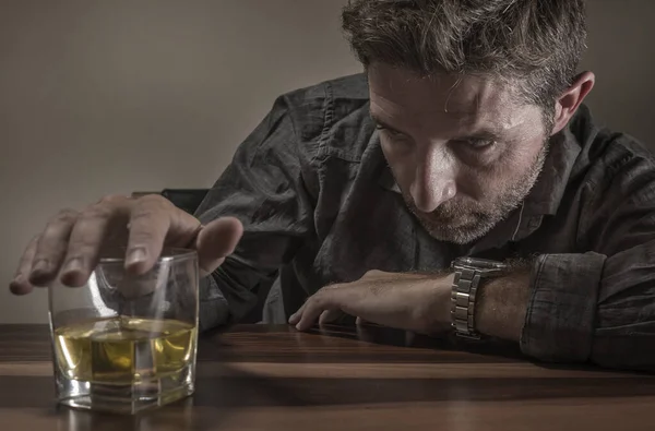Uomo alcolizzato depresso e premuroso sulla quarantina davanti a bicchiere di whisky sprecato e stressato aggrappato alla tentazione di bere in dipendenza da alcol e problemi di alcolismo — Foto Stock