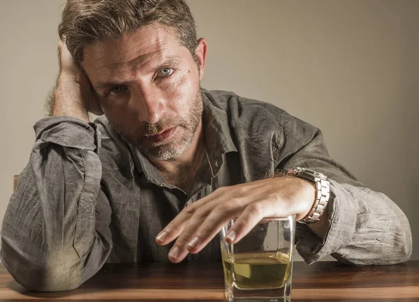 Depressiver und nachdenklicher Alkoholiker um die 40 vor verschwendetem Whiskeyglas und gestresstem Festhalten an der Versuchung, in Alkoholsucht und Alkoholismus zu trinken — Stockfoto