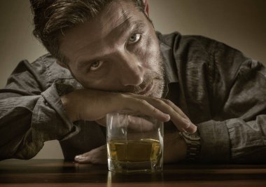 Çaresiz alkolik adam. depresif bağımlı viski bardağının önünde izole edilmiş dramatik bir ifadeyle içmemeye çalışıyor alkolizm ve alkol bağımlılığı sorunu yaşıyor.