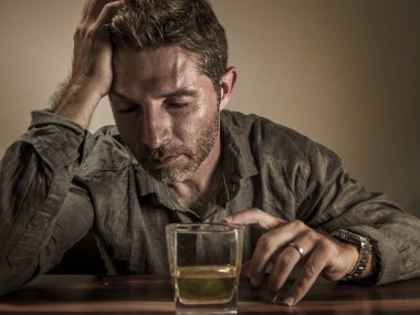 Çekici alkolik adam. Depresyondaki bağımlı viski bardağının önünde izole edilmiş sarhoş ve alkolizm ve alkol bağımlılığı çeken dramatik bir ifadeyle harcanmış.