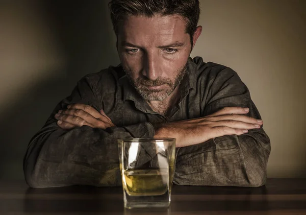 Hombre alcohólico desesperado. adicto deprimido aislado frente al vaso de whisky tratando de no beber en la expresión dramática que sufre alcoholismo y problema de adicción al alcohol — Foto de Stock