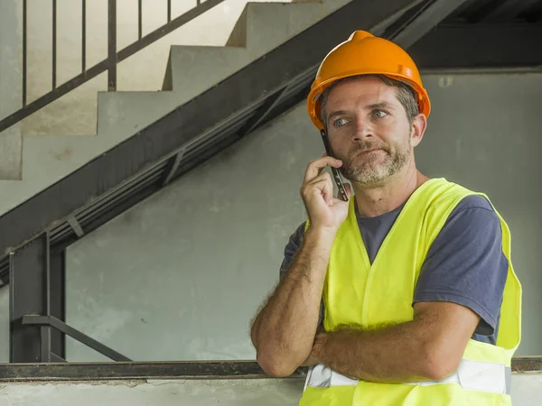 建筑工人或有压力的承包商头戴硬礼帽，穿着背心在手机上讲话，对工作压力大或建筑工地出错感到不快 — 图库照片